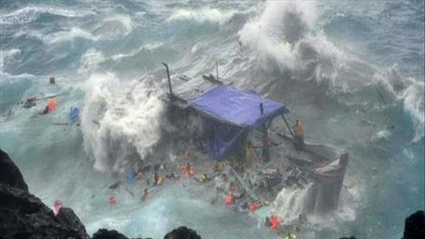 A timber asylum seeker boat smashes against rocks off Christmas Island.