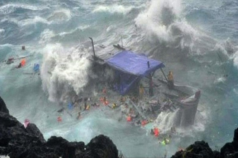 The timber asylum seeker boat smashes against the rocks