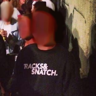 An unidentifiable man wearing a Tracks and Snatch jumper.
