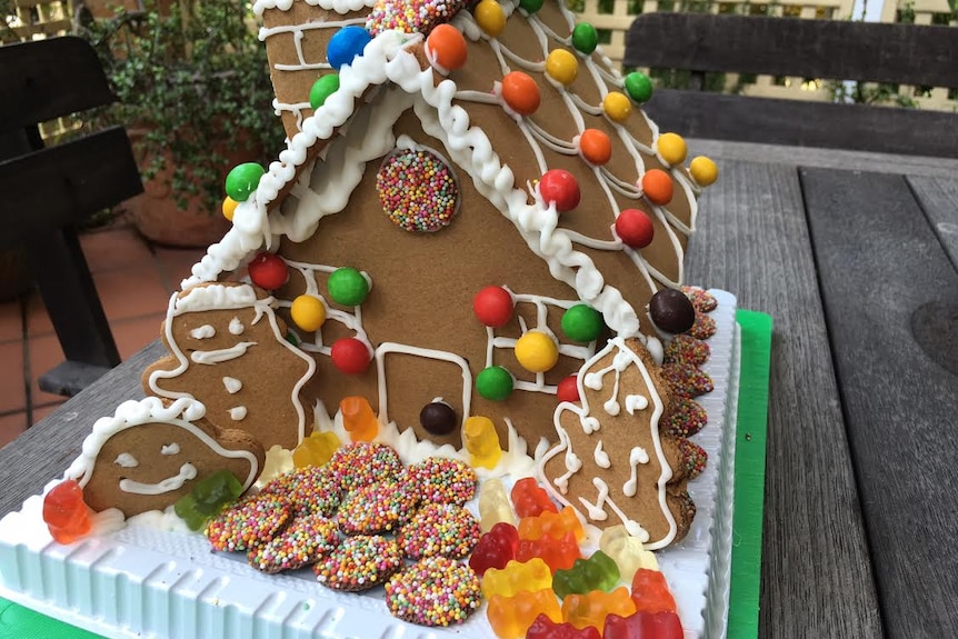A decorated gingerbread house ready for a Christmas feast