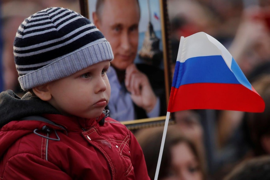 Young child waves a Russian flag
