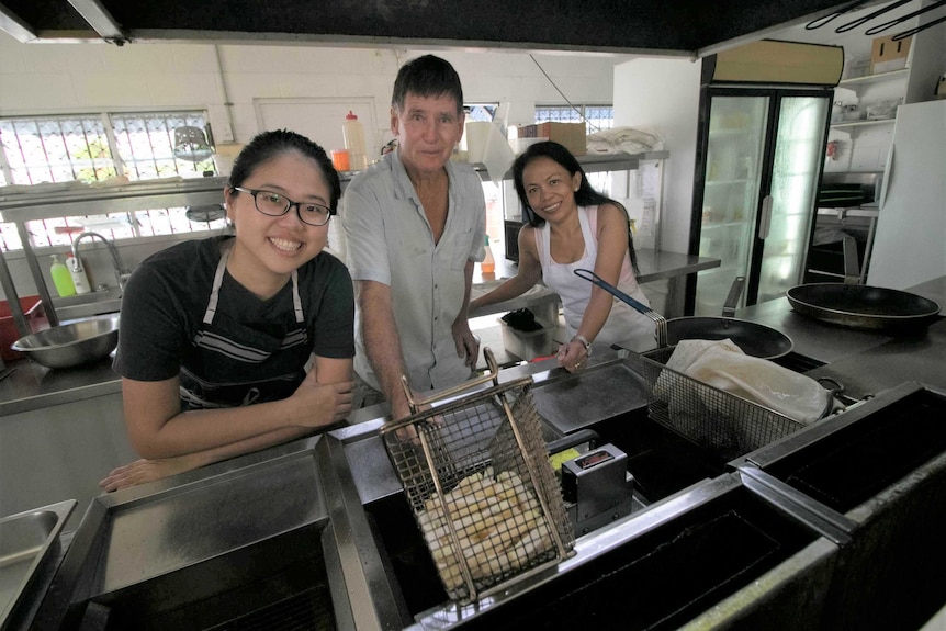 A man and two women in takeaway store.