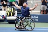 A smiling Dylan Alcott holds his arms out wide on court after the final point of his US Open quad singles final.