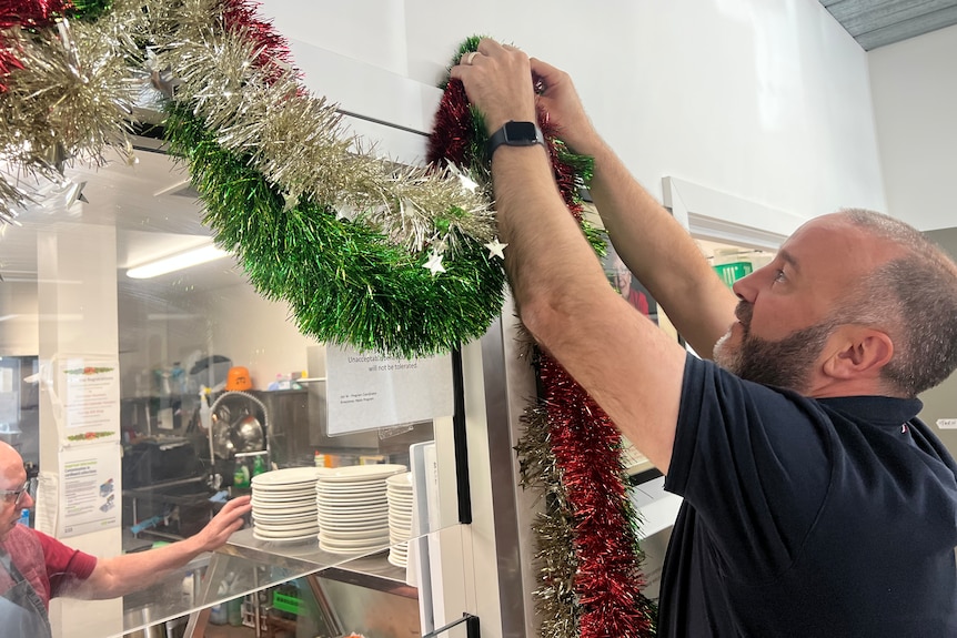 uniting ballarat senior manager of community engagement and support warrick davison hanging christmas decorations