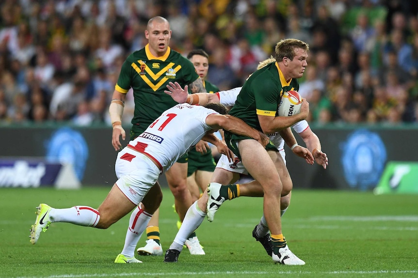 Jake Trbojevic is tackled by two England players as he plays for the Kangaroos in the Rugby League World Cup in Melbourne.