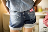 A woman with a sanitary pad in her back pocket.