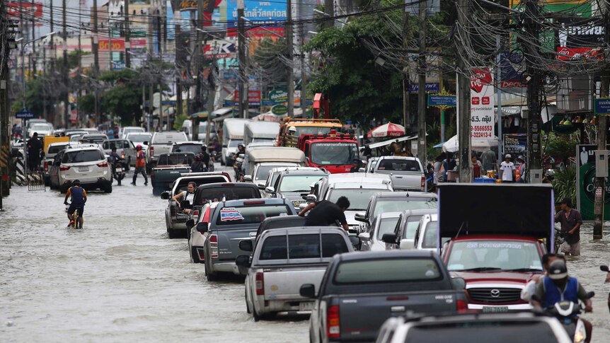 Residents drive through the flooded streets in southern Thailand.