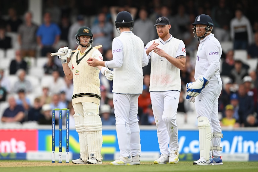 Ben Stokes reviews a decision while Steve Smith talks to England fielders