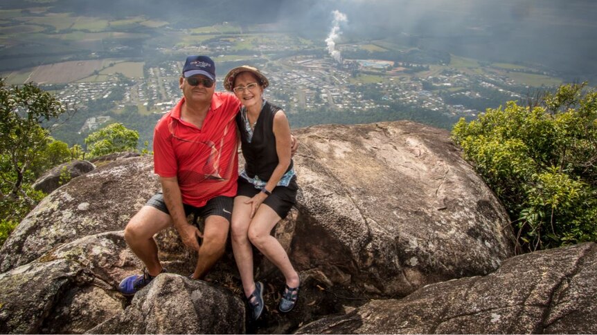 A man and a woman sit at a lookout on Mount Tyson.