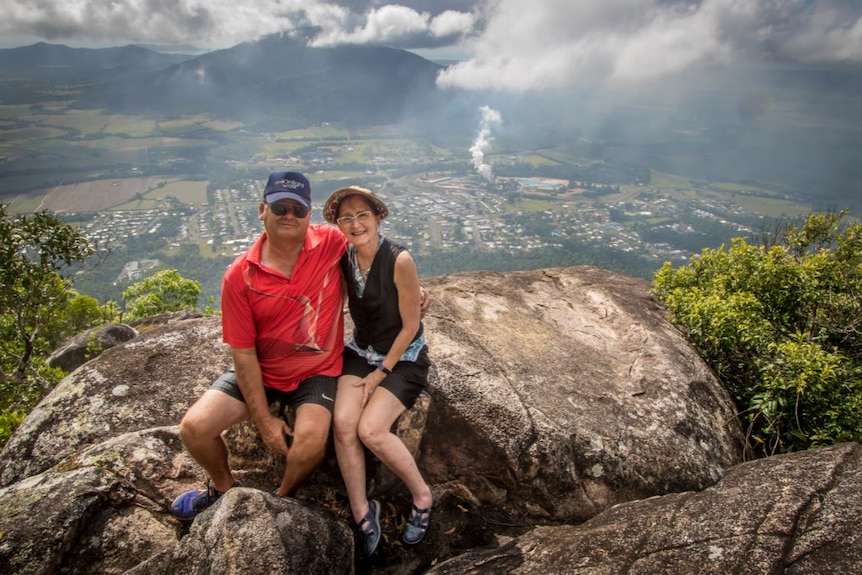 A man and a woman sit at a lookout on Mount Tyson.