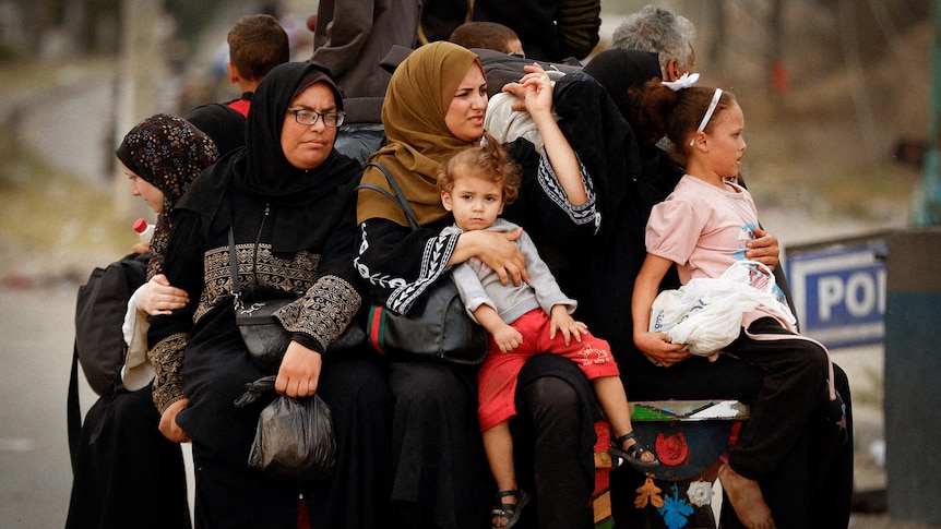 A group of women and children on the back of a van 