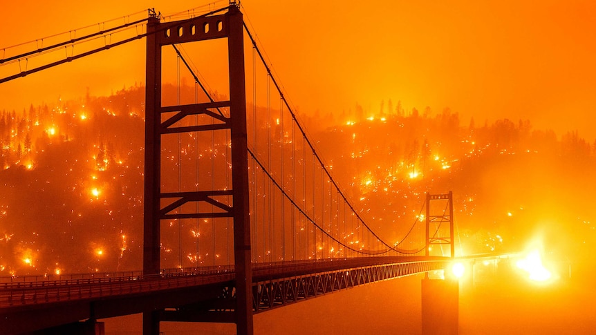 Embers light up a hillside as it glows bright orange behind the Bidwell Bar Bridge.