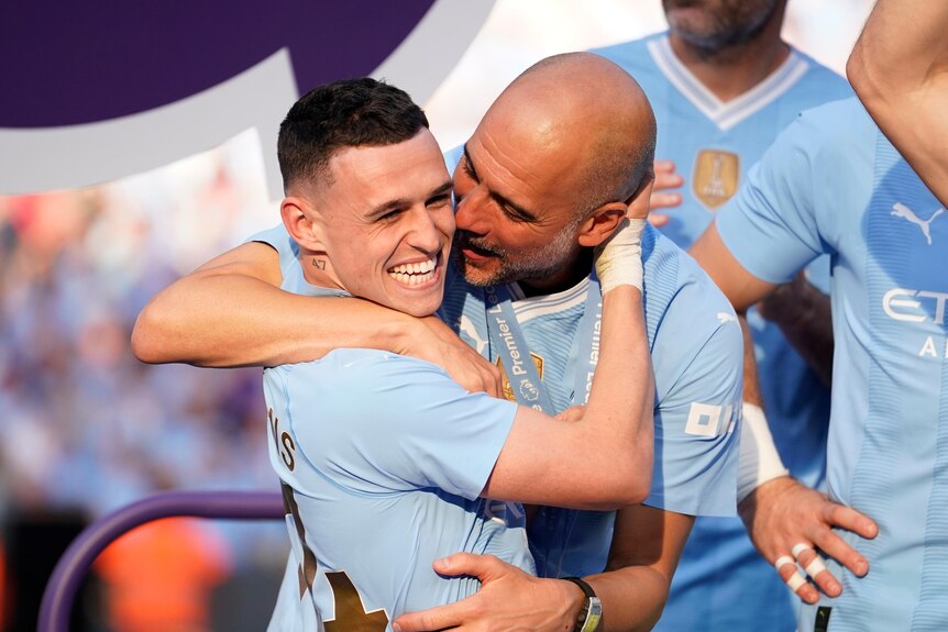 Phil Foden is hugged by Pep Guardiola