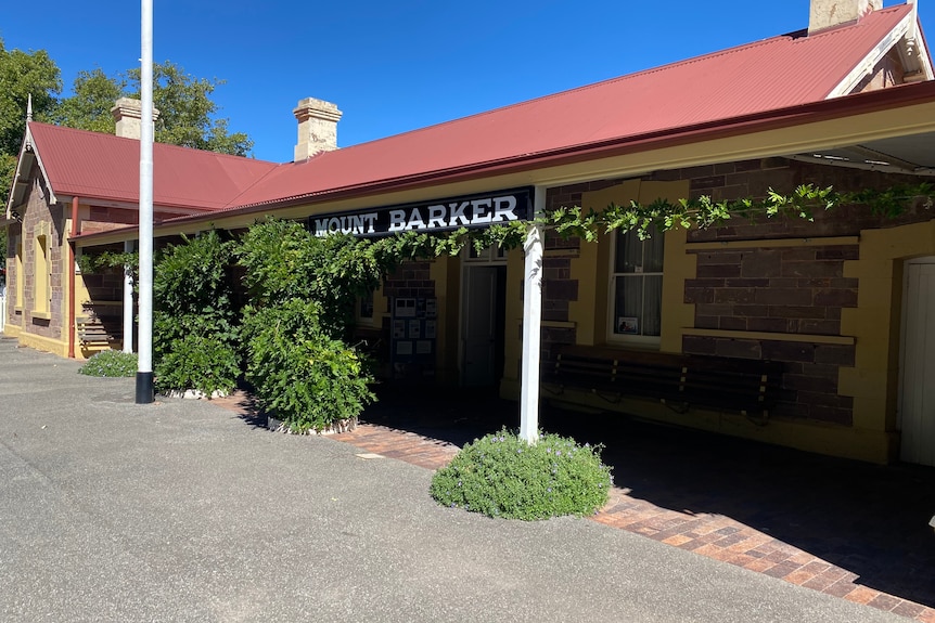 A historic building with vines on the veranda and a sign saying Mt Barker