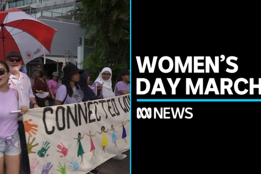 Women's Day March: Group of people march while holding a banner.