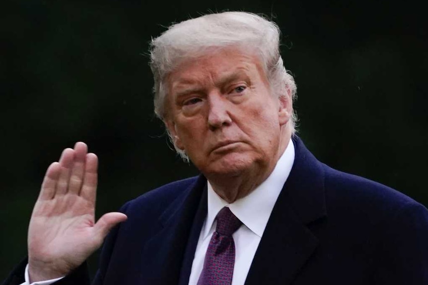 President Donald Trump waves as he walks from Marine One to the White House