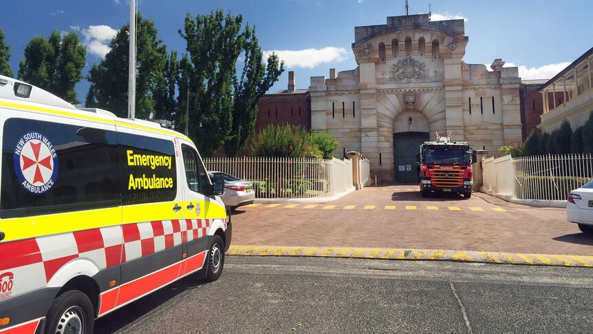A prison with emergency vehicles out the front.