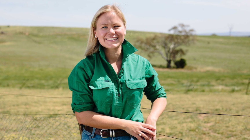 Blonde woman in green shirt standing outside