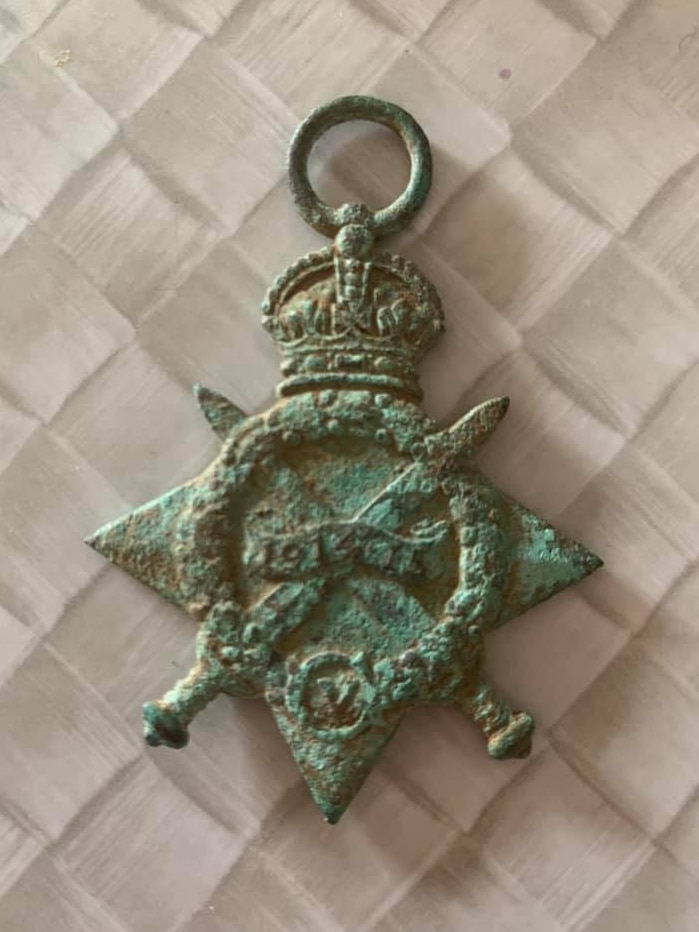 The front of a British Navy war medal with green patches and '1914-15' engraved on it.