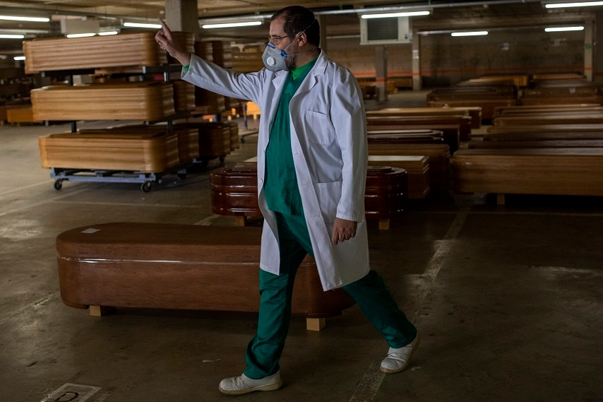 Coffins and a worker giving directions.