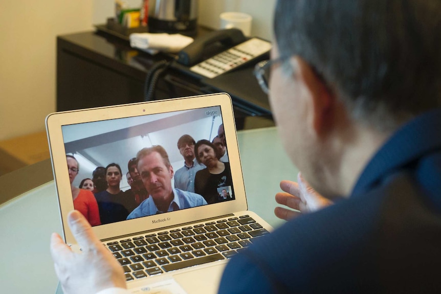Looking over the shoulder of Ban Ki-moon, you look at a MacBook Air with a Skype screen of UN staff.