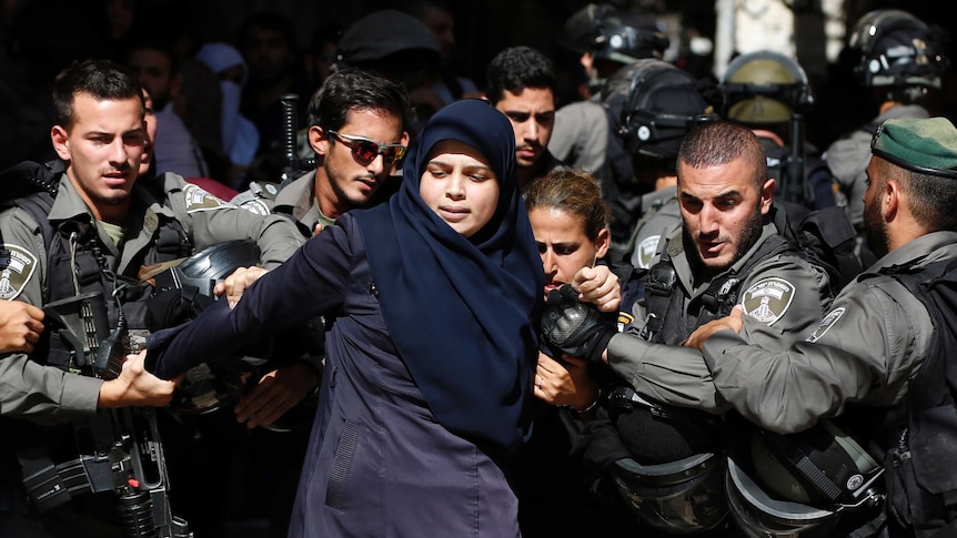 Israeli security forces arrest a Palestinian woman during clashes at al-Aqsa mosque