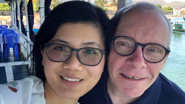 a man and a woman wearing glasses smiling and looking forward