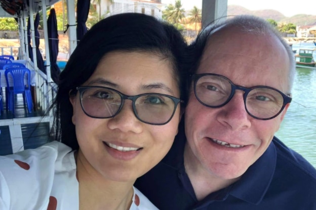 a man and a woman wearing glasses smiling and looking forward