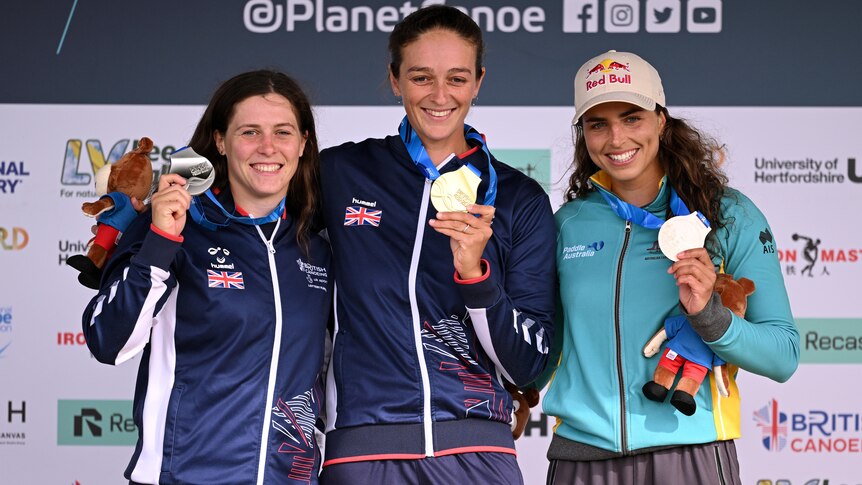 Three medallists in the women's C1 stand on the podium at the 2023 ICF Canoe Slalom World Championships.