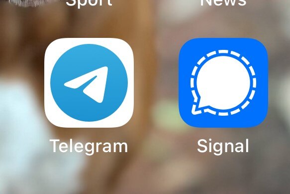 A phone screen displaying icons for the Telegram and Signal apps.