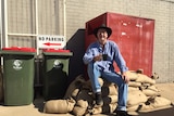 A man sitting on sandbags with a cup of tea