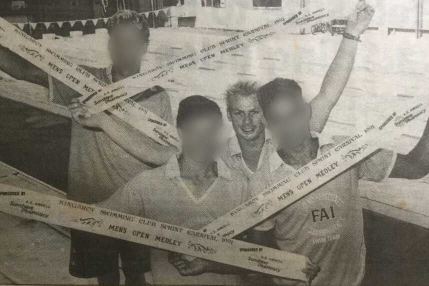 Teenage boys holding their swimming prize ribbons in an old newspaper article.