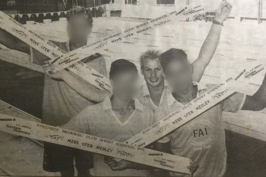 Teenage boys holding their swimming prize ribbons in an old newspaper article.