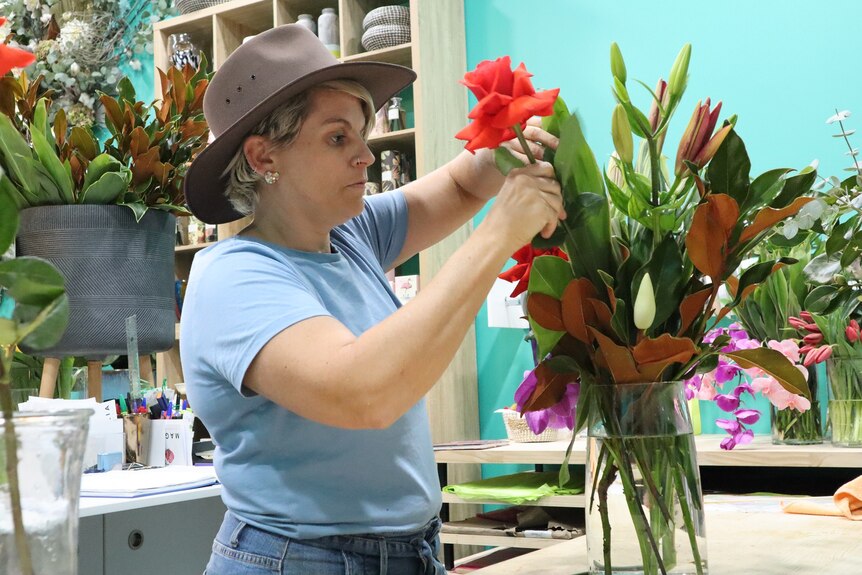 Darwin florist Samantha Perry organises flowers inside her shop.
