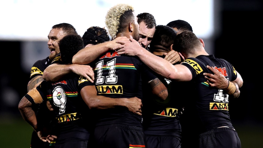 A group of Penrith Panthers NRL players group together as they celebrate beating the Parramatta Eels.
