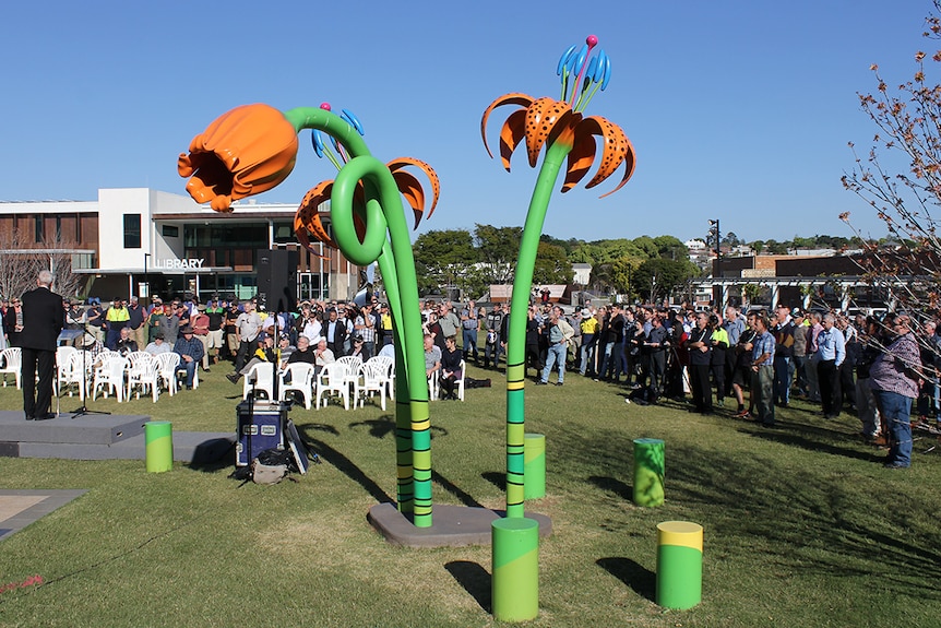 A crowd stand in a Toowoomba park