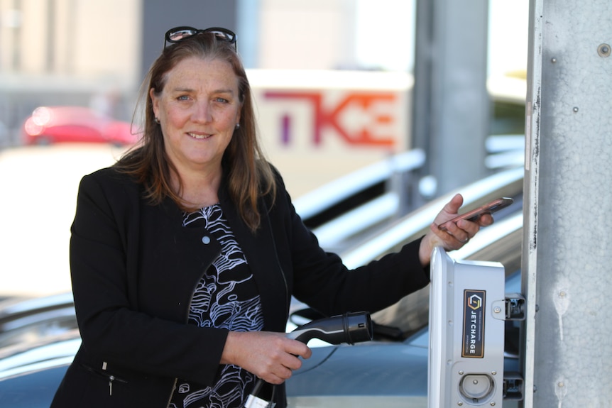 Renate Egan charging an electric car.