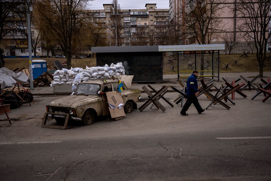 A militia man walks in a checkpoint set up at a road heading to the city of Kyiv.