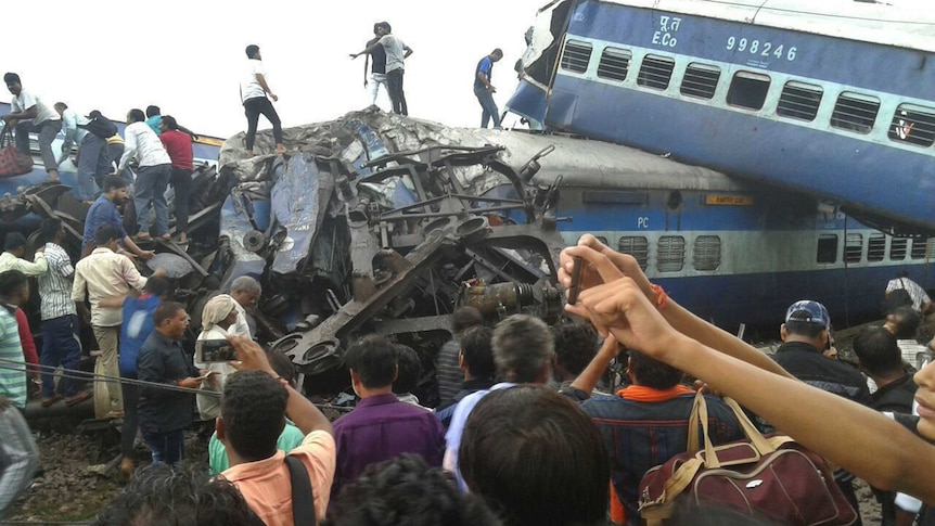 Railway police and local volunteers look for survivors in the upturned coaches.