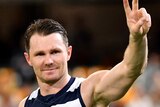Patrick Dangerfield smiles and gives the peace sign towards the crowd