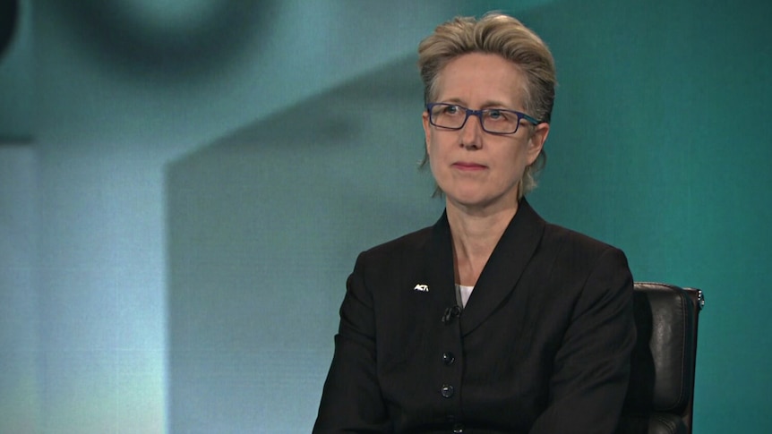 Sally McManus wearing a black jacket sitting at a desk.