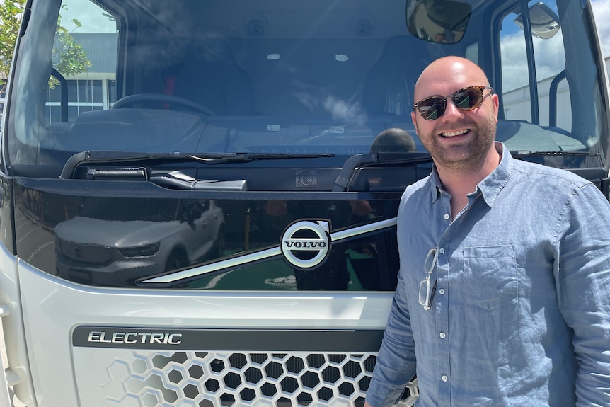 Volvo's e-mobility solutions manager Tim Camilleri posing with sunglasses on in front of a truk.