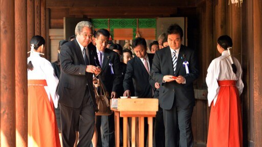 A group of Japanese lawmakers drink sake for purification at the controversial Yasukuni shrine.