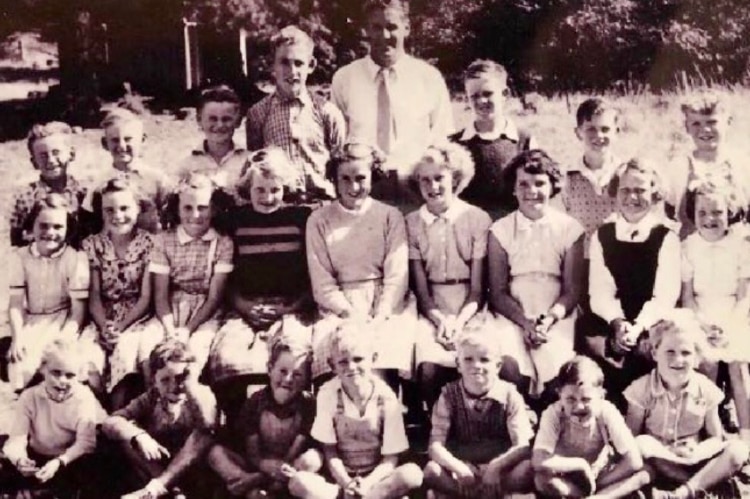 The Stoneyford Primary School photo in 1955. children sit in 3 rows with the principal