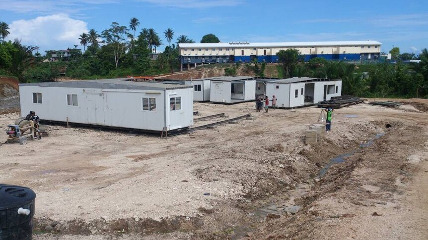 Ongoing work at one of the new refugee accommodation sites on Manus Island. There are portables on a large cleared dirt site.