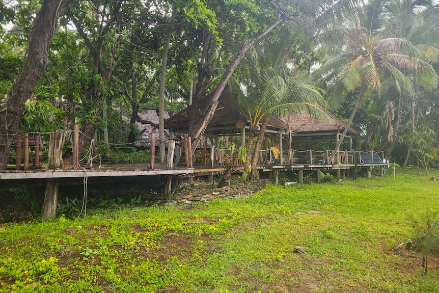 A boardwalk with shelters and palm trees