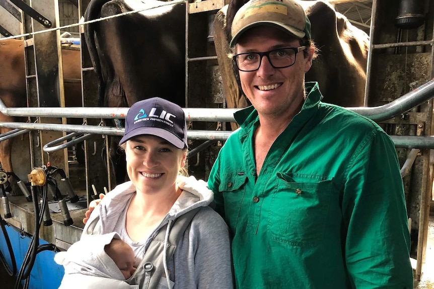 Sophie and James Greenacre holding baby in dairy