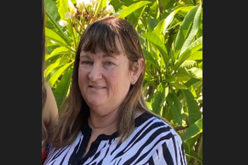 A woman in a striped top smiling at the camera.