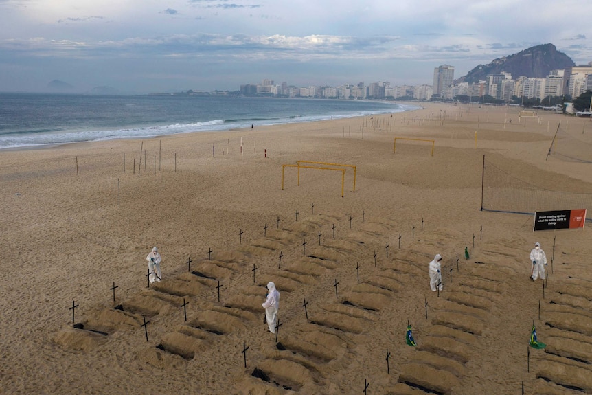 Activists in hazmat costumes dig symbolic graves on Copacabana beach as a protest in this image taken by drone.