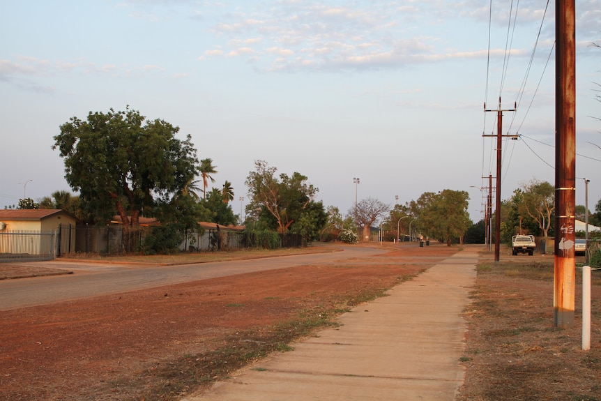 The main strip of Derby, a narrow road surrounded by red dirt and bushy trees.